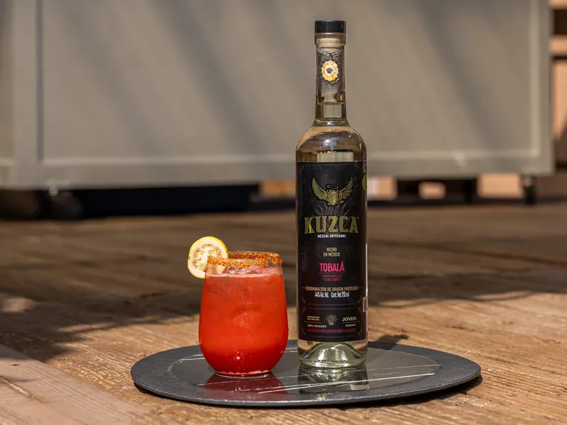 Mezcalita Guapachosa à la goyave, verre givré, à côté d'une bouteille de Kuzca Tobalá